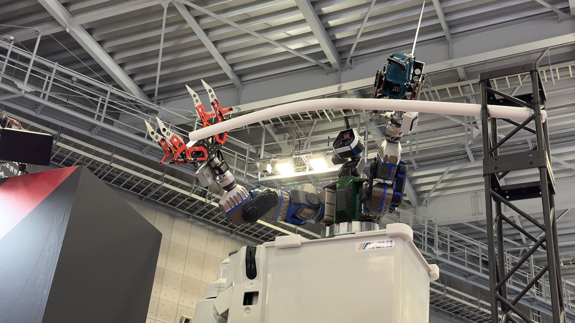 右手に巨大ヅメ、左手にチェーンソー 人々を高所から見下ろすロボット