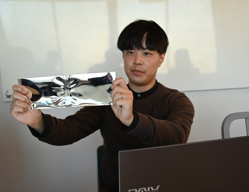 ヴォクセルの外側を覆う鏡面仕上げ材のプロトタイプを手に説明する笹村氏