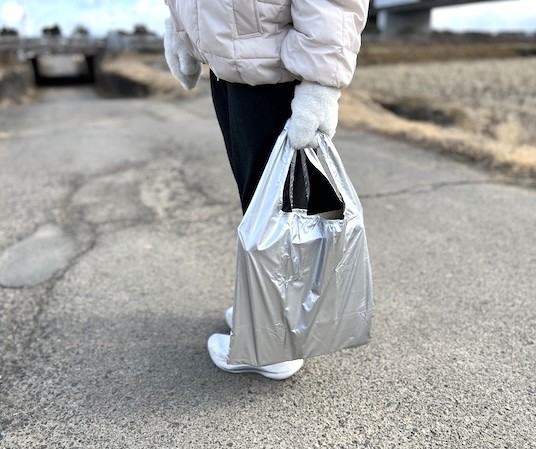 身長約155cmの人が折りたたみマルシェバッグを持っているところ