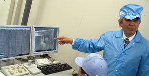 写真3　電子顕微鏡を使ったチップ分析について説明する佐藤信夫氏