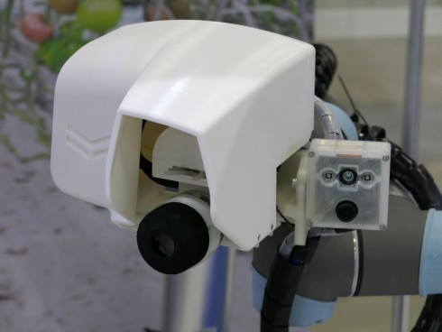協働ロボットの先端に装着された「収穫するトマトの形状／姿勢認識」を行うカメラと「吸着切断ハンド」