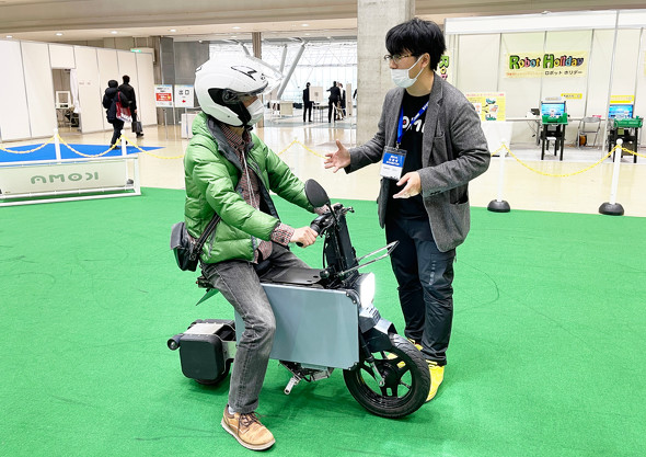 展示会の来場者に「タタメルバイク」を説明する生駒氏（右）