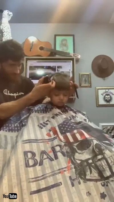 uLittle Boy Falls Asleep While Getting His Hair Cut By Barber - 1200925v