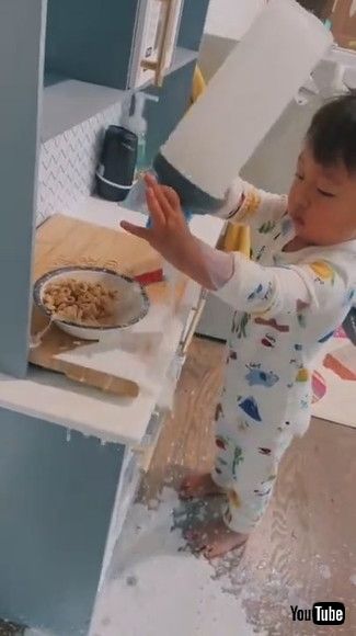 「Toddler Spills Milk on the Floor While Trying to Pour it Into Bowl of Cereal - 1202181」