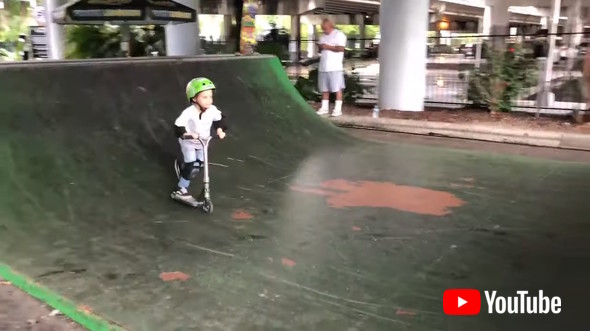 Little Kid Shows Tricks On Scooter While Practicing For Competition In Skatepark