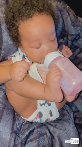 「Toddler Drinks Milk From Bottle While Holding it With Feet - 1278029」