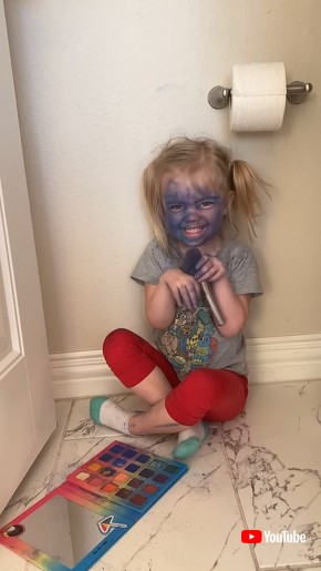 Little Girl Paints Her Face Blue With Makeup Palette and Brush