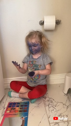 Little Girl Paints Her Face Blue With Makeup Palette and Brush